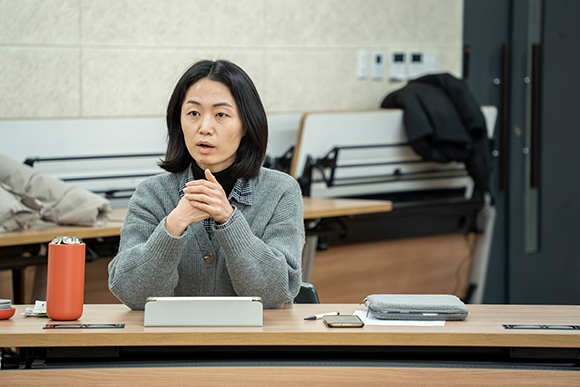 배우 한혜진. 어깨까지 오는 단발 머리에 회색 가디건을 입었다. 가디건 속에는 검은색과 하얀색 체크무늬 남방이 보인다.