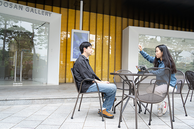 배우 양대은과 배우 성수연. 양대은은 검은 긴소매 셔츠에 청바지 차림이고, 성수연은 푸른색 긴소매 셔츠에 하얀색 바지를 입었다. 
            성수연이 오른손을 머리 높이로 들어 무언가를 설명하고 있다.