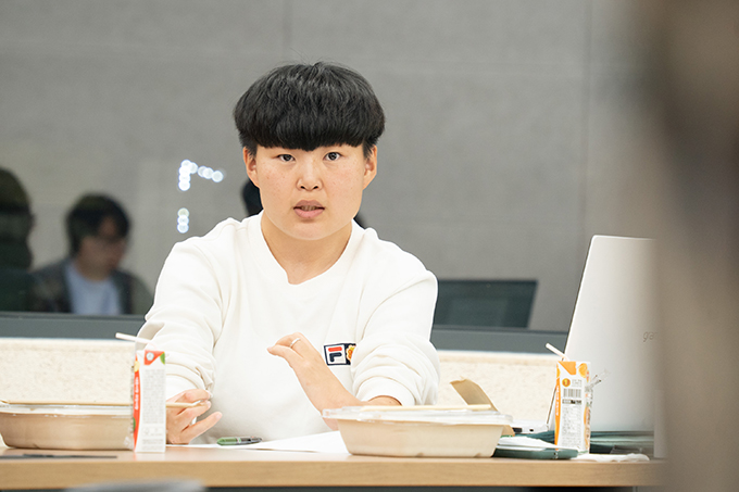 좌담 참여자 임지윤. 빈틈없는 앞머리를 눈썹 아래까지 내린 짧은 커트 머리다.
하얀색 긴소매 라운드 티셔츠를 입고 있다.