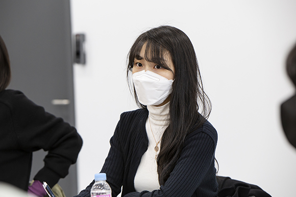 작가 이승혜. 가슴까지 오는 검은 생머리와 시스루뱅이 눈에 띈다. 흰 목폴라티 위에 검은 가디건을 걸치고 동그란 팬던트 목걸이를 착용하였다.