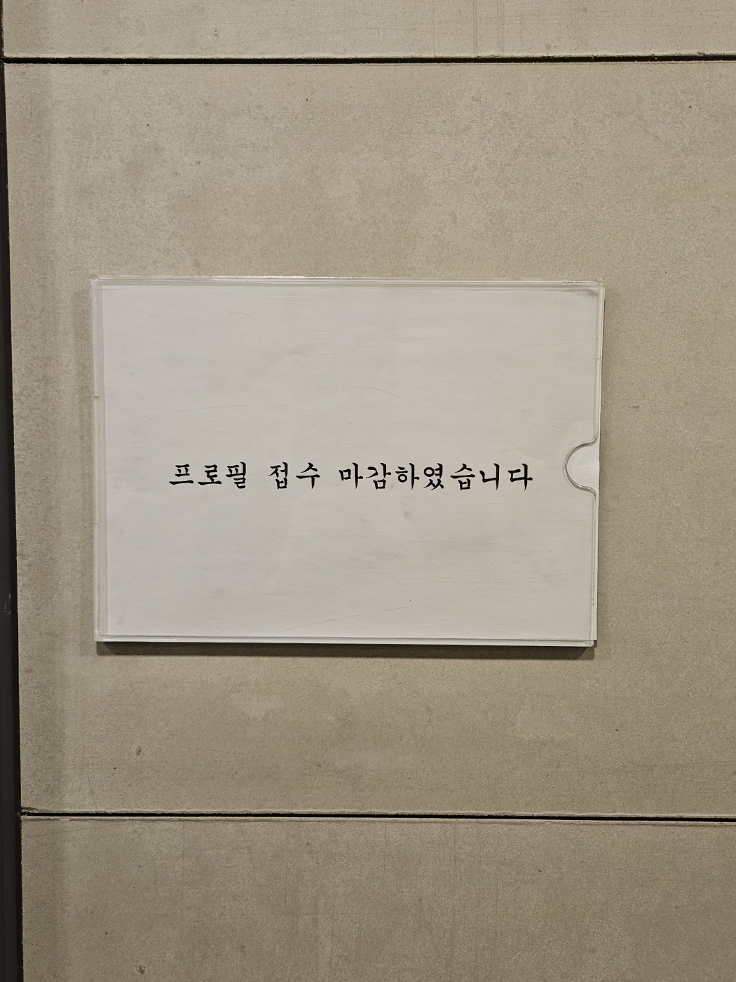 어느 사무실 복도 벽면에 “프로필 접수 마감하였습니다”라는 간단한 안내문이 붙어 있다.