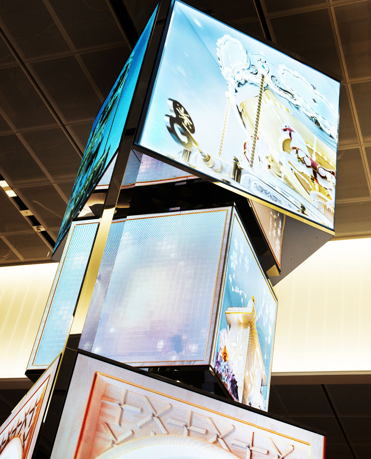 반짝이는 이미지를 담은 미디어들이 블록 형태로 적층되어 있다. 사진에서 확인할 수 있는 블록은 총 세 개다. 블록의 위 아래는 거울 같은 재질로 이루어져 그 맞은 편에 있는 이미지가 반사되어 보이며, 가로 면들에는 서로 다른 이미지가 보인다.